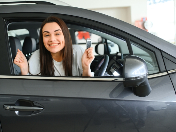 Woman Showing of Keys inside a Black Car