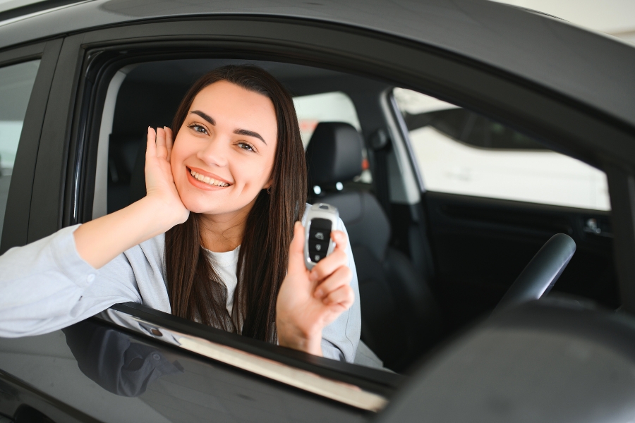 Woman Showing of Keys inside a Black Car